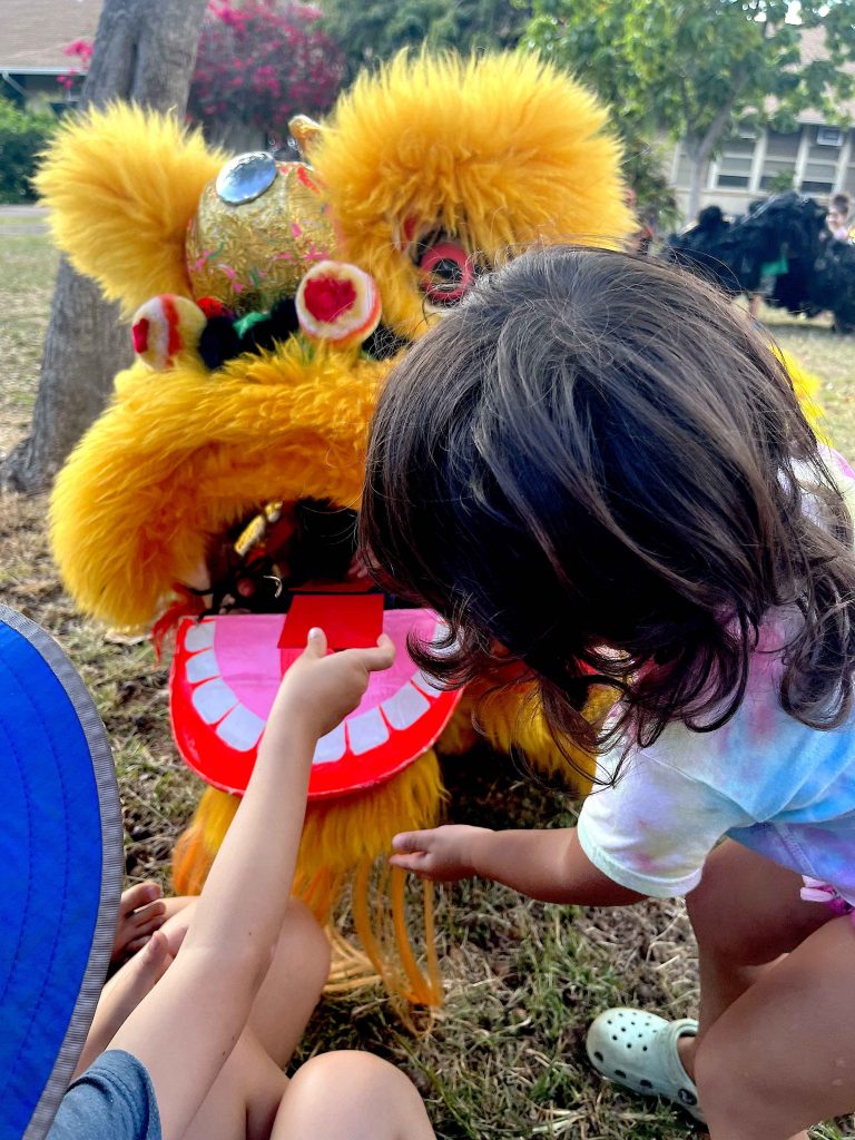 child feeding lai see (good luck envelope) to Chinese lion