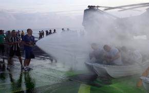 <p><strong>SF Fig. 3.1.</strong> (<strong>B</strong>) The act of “crossing the line” across the equator has become a celebratory rite of passage in recent years, as sailors are doused with water aboard the <em>USS New Orleans</em>.</p>
