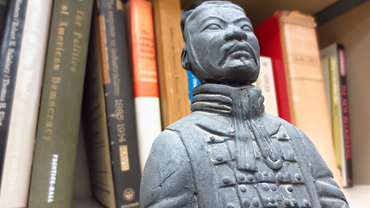 Emperor Qinshihuang's terracotta soldier replica in front of books