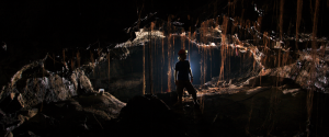 A researcher in a cave passage filled with roots on Hawaiʻi Island. (Photo credit: Kenneth Ingham)
