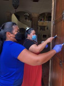 Participants apply conservation wax to the bronze doors of Honolulu Hale.
