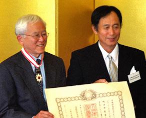 George Tanabe, left, accepts the commendation from Consul General Toyoei Shigeeda. 