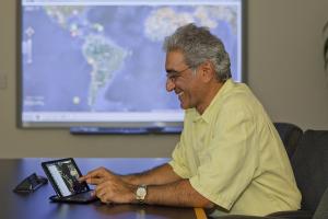 Pacific Disaster Center Executive Director Ray Shirkhodai demonstrates PDC's Disaster Alert app.