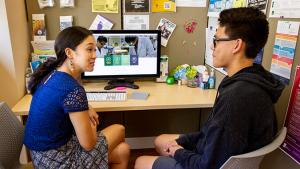 Jain Wi, an academic advisor for the College of Natural Sciences assists student Dean Carillo