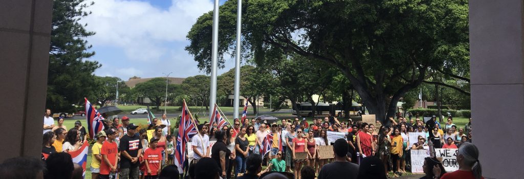 People gathered with Hawaiian flags to protest the arrests of elders atop Maunakea