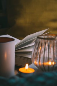 an open chapter book with soothing candles surrounding it