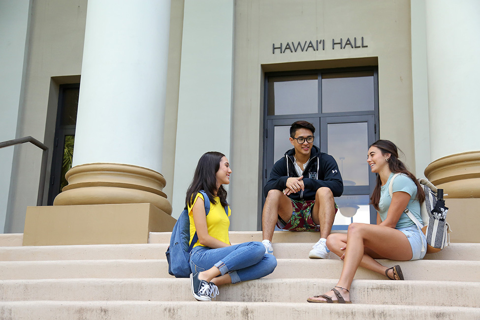 student sitting on the steps of Hawaii Hall