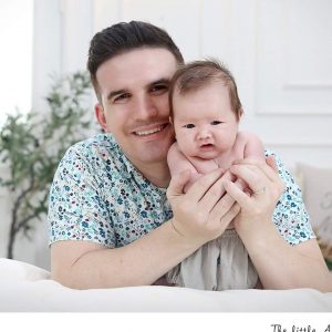 Nathan Mueller sitting holding baby.