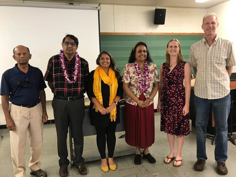 six people posing for a photo in a classroom