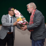 Gregory Maskarinec receiving flowers from a Nepali colleague