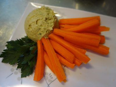plated hummus with carrot sticks on a plate