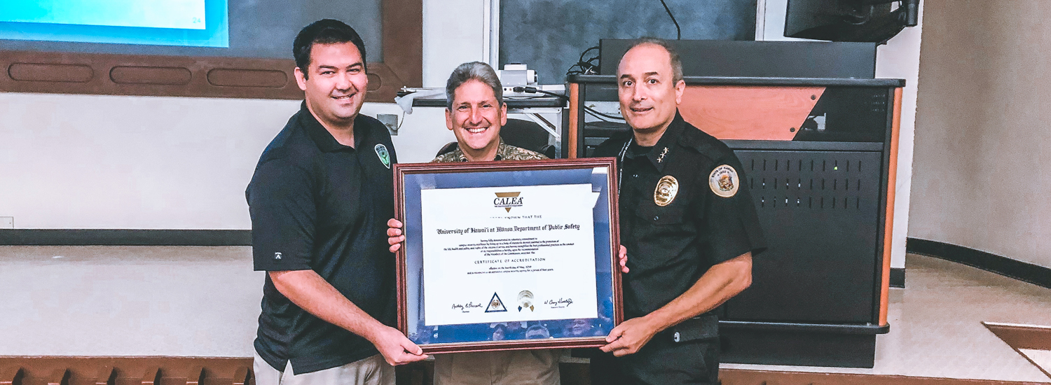 Daniel Tuttle, President Lassner, and Chief Black holding the CALEA certificate