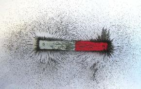 <p><strong>SF Fig. 7.5.</strong> The orientation of iron fillings makes the magnetic field lines around a bar magnet visible. Iron is a magnetic material that is either repelled or attracted to the two poles of the bar magnet.</p>