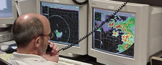 picture of weather service meterologist observing the development of weather patterns on computer monitor