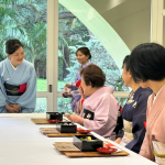 Akiko-sensei in pale blue kimono greeting to the guests.