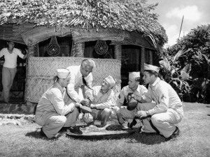 Photo of shop owner demonstrating how to pound poi to soldiers 