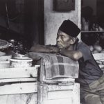 Photograph of Indonesian man in shop by Penny Kaiman-Rayner