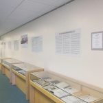 A wide shot of display tables and informational posters.