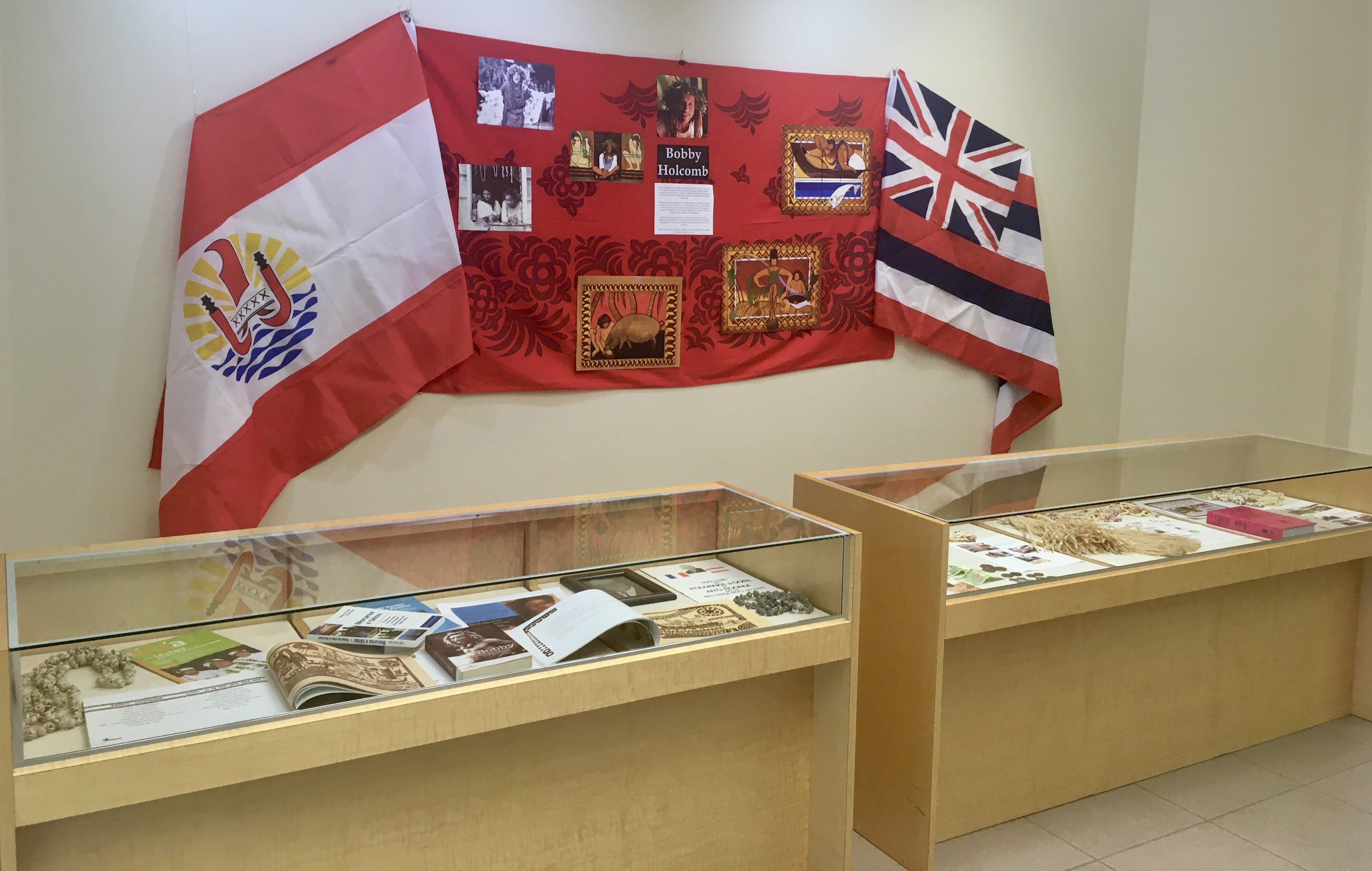 A display for Bobby Holcomb flanked by the flags of french polynesia and hawaii