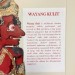 A shadow puppet next to a description of Wayang Kulit traditional shadow puppetry