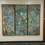 An illustrated three panel display full of plants and birds