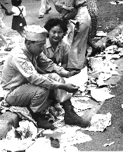 Sgt. Shigeh Fukuda of 442nd RCT and his girl, Miss Edna Ota, look at discharge papers