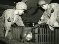 Two soldiers fixing a Jeep