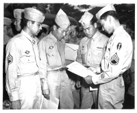 Four soldiers examine discharge papers