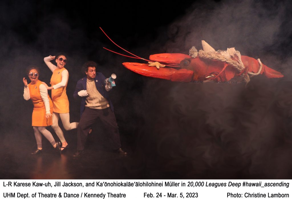 3 college actors fending off a giant lobster, 2 wearing matching outfits. Text: L-R Karese Kaw-uh, Jill Jackson, and Ka’ōnohiokalāe’ālohilohinei Müller in 20,000 Leagues Deep #hawaii_ascending. UHM Dept. of Theatre & Dance / Kennedy Theatre           Feb. 24 - Mar. 5, 2023                  Photo: Christine Lamborn.