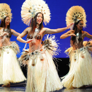 Three dancers in traditional Tahitian garb