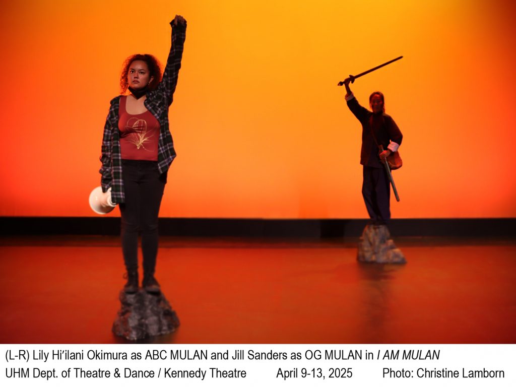 Photo of two women standing on rock on a stage with an orange/red background. Front left holds fist in the air an back right holds up a sword. (L-R) Lili Hi'ilani Okimura as ABC MULAN and Jill Sanders as OG MULAN in I AM MULAN. UHM Dept. of Theatre & Dance / Kennedy Theatre. April 9-13, 2025. Photo: Christine Lamborn