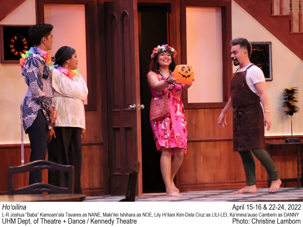 College actor walks through a door holding a Halloween pumpkin bucket. 3 college actors watch from inside. TEXT: Ho‘oilina. April 15-16 & 22-24, 2022 L-R Joshua “Baba” Kamoaniʻala Tavares as NANE, Makiʻilei Ishihara as NOE, Lily Hiʻilani Kim-Dela Cruz as LILI-LEI, Kaʻiminaʻauao Cambern as DANNY. UHM Dept. of Theatre + Dance / Kennedy Theatre. Photo: Christine Lamborn.