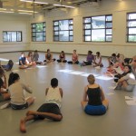 Students in dance classroom sitting in a circle