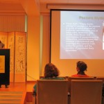 Lecturer at podium which reads "Center for Korean Studies" presenting slide show entitled "Posture Myths"