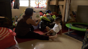 Puanani Akaka, UH accelerated online degree student, reads to her son Carter.