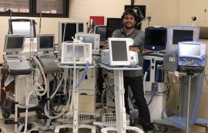 Kapi‘olani CC Assistant Professor Robert Vega stands with ventilators for healthcare organizations.