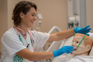 Nursing student with a manikin in the UH Translational Health Science Simulation Center
