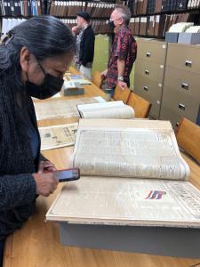 Pamela Alconcel observes original Hawaiian language newspapers at Bishop Museum.