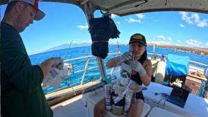 UH Mānoa students prepare water samplers for deployment at Mala Wharf. Photo credit: Andrea Kealoha