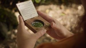 A TEAM student uses a densiometer (a handheld convex mirror) to measure the canopy cover.