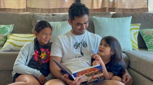 Kaʻiuokalani Damas reading the book with daughters Haliʻi and Iunia.