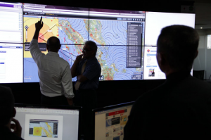 Officials examine earthquake and tsunami information.