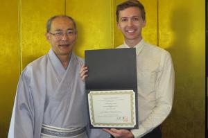 Joseph Cardello holds his certificate, presented by Consul General Yasushi Misawa.