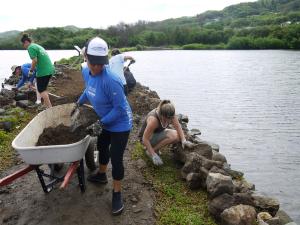 Volunteers repair the rock wall of Waikalua Loko Fishpond. Courtesy Oregon Museum of Science and Ind