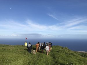 Students looking at a Hawaiian flag in Kahikinui, Maui