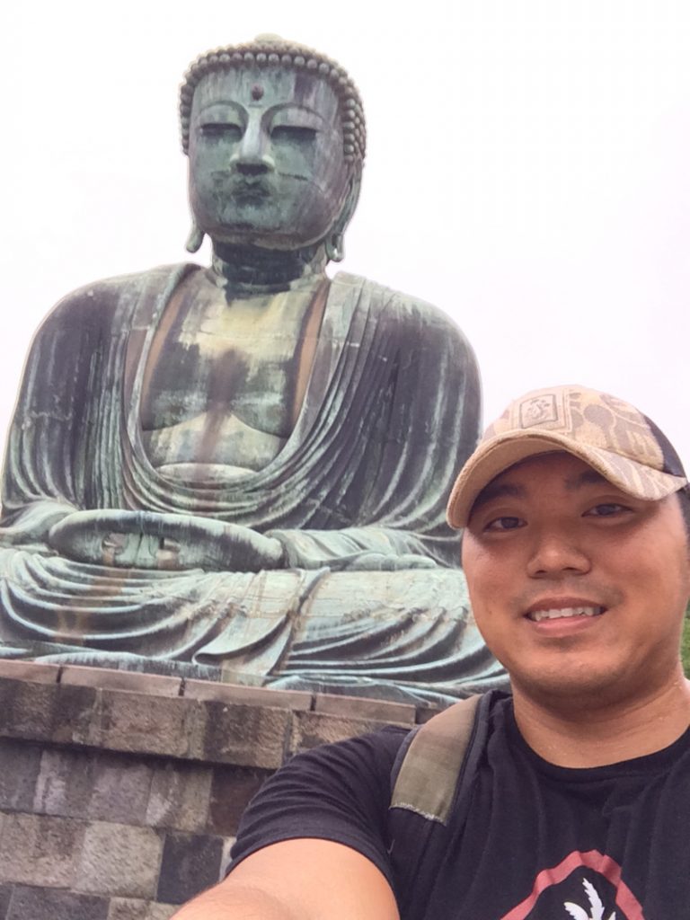 Eric Batangan selfie next to a Buddha statue