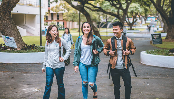 three students walking and chatting on campus