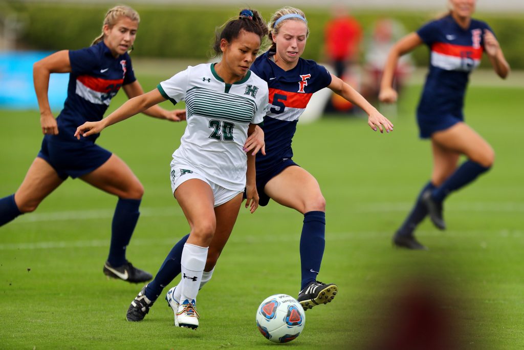 University of Hawaii at Manoa Women's Soccer Player dribbling a ball