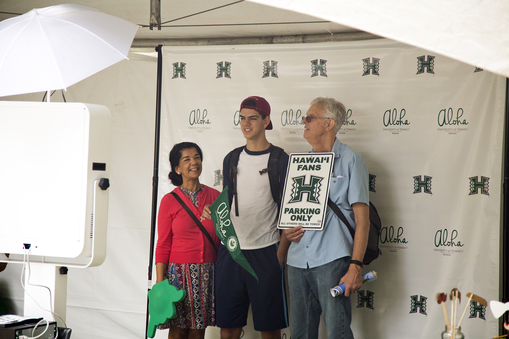 student with family at an event photo booth