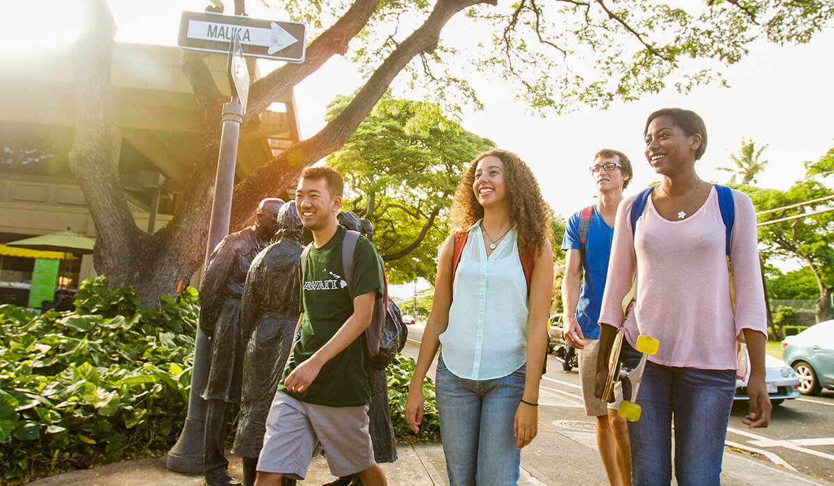 Smiling students walking towards the lower campus, and near the Richardson School of Law